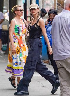 a woman walking down the street with her hat on