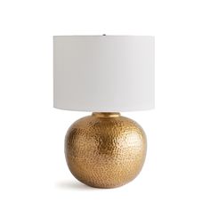 a gold table lamp with a white shade on the top and bottom part of it