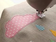 the sewing machine is on top of the pink fabric with white polka dots and an umbrella