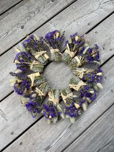 a wreath made out of dried lavenders on a wooden deck with the word love written in it