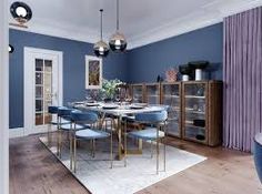 a dining room with blue walls and wooden floors