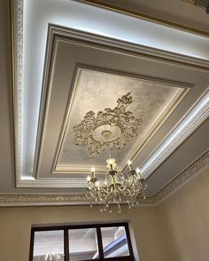 a chandelier hanging from the ceiling in a room with white walls and ceilings