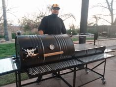 a man standing next to a large barrel grill