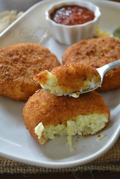 two fried food items on a plate with dipping sauce