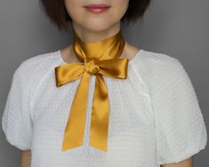 This golden yellow scarf is made from 100% natural silk. This Golden yellow silk bow tiу adds a silky, sophisticated accent for year-round wear. This accessory can be worn in different ways: a necklace with a tie on the back, a headband, or a wrist. The silk scarf is a perfect way to accentuate simple clothes to look classic. Great gift idea Composition: 100% natural silk Size: Approximately Width: 4 cm - 1 1/2 inches Length: 128 cm - 50 Inches 153 cm - 60 Inches 177 cm - 70 Inches Handmade item Classic Gold Silk Scarf, Elegant Silk Scarf With Ribbon For Gift, Elegant Scarves With Ribbon For Gift, Chic Gold Silk Scarves, Chic Gold Silk Scarf, Silk Scarf With Ribbon For Gift, Elegant Silk Scarf With Ribbon, Classic Gold Silk Scarf For Formal Occasions, Elegant Silk Neckwear For Gift