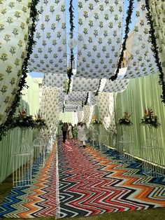 the inside of a tent with colorful carpeting and flowers on it's sides