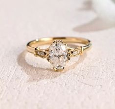 a close up of a ring with a diamond on the top and side, sitting on a white surface