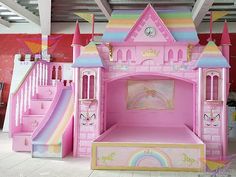 there is a pink princess castle with slides in the floor and stairs to the second floor