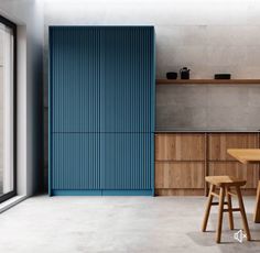 a kitchen with wooden tables and stools next to an open door that leads outside