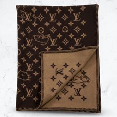 the louis vuitton scarf is brown and tan with black stars on it,