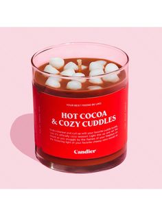 hot cocoa and cozy cuddles in a glass jar on a pink background with the lid open