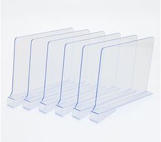 four clear acrylic displays are lined up on a white surface, one is empty