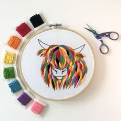 an embroidery project with scissors and thread on the table