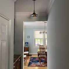 an open door leading to a kitchen and dining room with wood furniture in the foreground