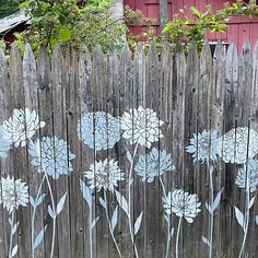 a wooden fence with flowers painted on it