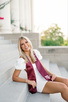 a woman sitting on the steps wearing a red and white dress with her legs crossed