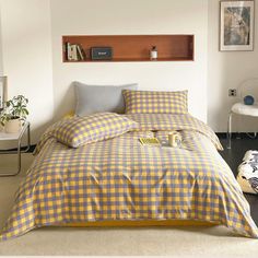 a yellow and white checkered comforter set on a bed in a room with black flooring