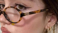 a close up of a woman wearing glasses with fake eyelashes on her face and nose