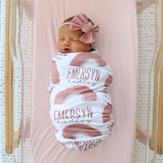 a baby girl sleeping in a pink crib with the name emersonsyn on it