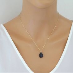 a woman wearing a necklace with a black stone on it