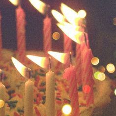 many candles are lit on a cake with frosting and sprinkles in the middle