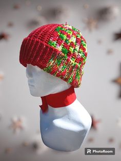 Crocheted hat with a flip brim. Multi-color, mostly red. Bells attached to top. Superwash Merino wool. Warm and stretchy. Red Adjustable Christmas Hat, Adjustable Red Hats For Holiday, Adjustable Red Hat For Holiday, Adjustable Red Christmas Hat, Red Fitted Mini Hats For Winter, Adjustable Brimmed Red Crochet Hat, Warm Red Winter Hat, Red Crochet Hat With Adjustable Short Brim, Handmade Red Mini Hat With Short Brim