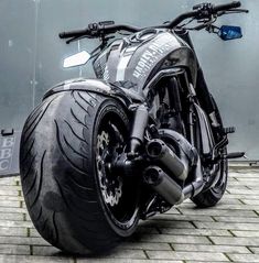 a black motorcycle parked on top of a brick road