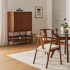 a dining room table with two chairs and a cabinet