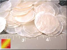 a pile of white discs sitting on top of a ruler