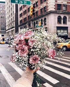 a bouquet of flowers sitting on the side of a street next to a cross walk