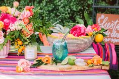 flowers and candles are on a table outside