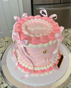 a pink and white cake sitting on top of a counter