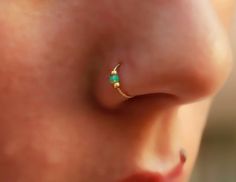 a woman's nose with a tiny gold nose ring on top of her nose