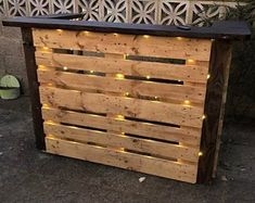 an outdoor bar made out of wooden pallets with lights on the top and bottom