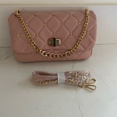 Cross Body And Hand Purse .Color Blush W/Diamond Quilt & Studs Gold Tone On Cover. Detachable Strap. Material Vegan Leather . Dimensions Are.5”Tall. 10.5”Wide. Msrp$129.00. Hand Purse, Studs Gold, Weekend Travel Bags, Vegan Leather Tote, Quilted Crossbody Bag, Vegan Leather Bag, Cross Body Purse, Pearl Leather, Color Blush