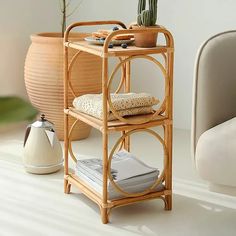 a bamboo shelf with some plants on top of it next to a chair and potted plant