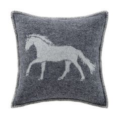 a grey and white pillow with a horse on it