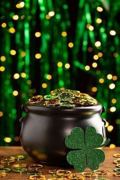 a pot full of gold coins next to a shamrock