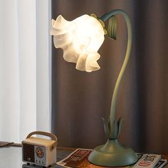 a lamp that is sitting on top of a table next to a book and radio