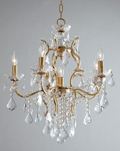 a gold chandelier with crystal drops hanging from it