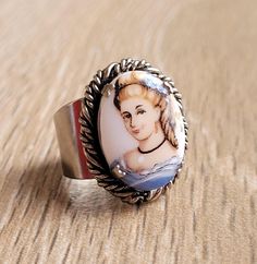 This is a beautiful vintage cameo porcelain ring. With a lady in blue (victorian familiar image) over the white porcelain inlay in a silver tone ring with a great swirled silver rim work. Condition: As found. Good vintage condition (please see photos carefully) These are vintage items and, as they have been previously loved, they may show signs of wear and age. Measures: front of the ring 2,2cm x 1,6cm / 7/8" x 5/8" Weight 6,5gr Vintage Cameo Enamel Jewelry, Vintage Cameo Jewelry In Enamel, Vintage Enamel Cameo Jewelry, Vintage Enamel Cabochon Rings, White Cameo Ring For Gift, Vintage Silver Enamel Ring For Wedding, Victorian Oval Enamel Ring As Gift, Victorian Oval Enamel Ring As A Gift, Images Victoriennes