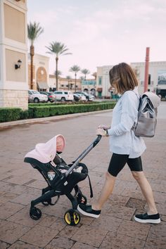 a woman pushing a stroller with a baby in it