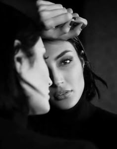 black and white photograph of two women touching each other's foreheads with their hands