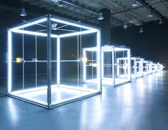 a group of glass cubes sitting inside of a building with lights on each side