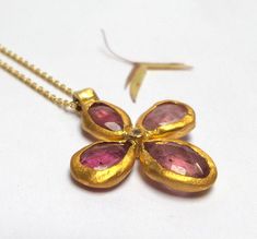 Tourmaline Flower Pendant - Beautiful Pink Tourmaline stone inlaid in 24K solid gold. inlaid diamond. The Pink Tourmaline flower pendant length 22mm. The Pink Tourmaline flower pendant - 440$. The Pink Tourmaline and diamond flower pendant in 18k solid gold Chain length 45cm - 660$. The pink Tourmaline and diamond flower pendant in oxidized sterling silver chain 50cm - 480$. Please let me know how do your necklace. Free Shipping The pendant will be packed in a Beautiful gift box. Your necklace w Gold Gemstone Necklaces With Flower Design, Gold Flower-shaped Gemstone Jewelry, Gold Flower Shaped Jewelry With Gemstone, Gold Flower Gemstone Jewelry, Gold Flower Shaped Gemstone Necklace, Handmade Yellow Gold Flower-shaped Necklace, Handmade Yellow Gold Flower Shaped Necklace, Yellow Gold Gemstone Necklace In Flower Shape, Yellow Gold Flower-shaped Gemstone Necklace