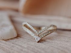 a diamond ring sitting on top of a bed