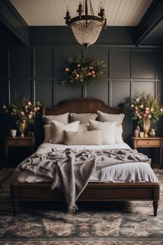 a large bed sitting in a bedroom next to two nightstands with flowers on them