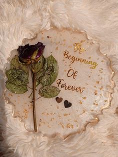 a white plate with a rose on it that says the beginning of forever in gold lettering