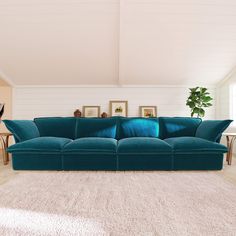 a large blue couch sitting in a living room on top of a white carpeted floor