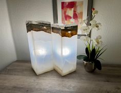 two white vases sitting on top of a wooden table